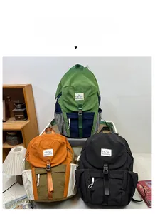 Three colorful nylon backpacks with mountain logo shown in a cozy interior setting