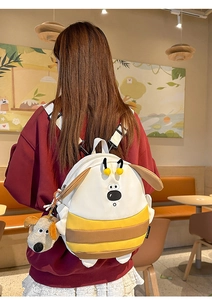Detail view of cartoon dog backpack with 3D ears and matching plush keychain charm