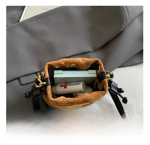 Internal storage view of mini quilted drawstring bucket bag with makeup and earbuds