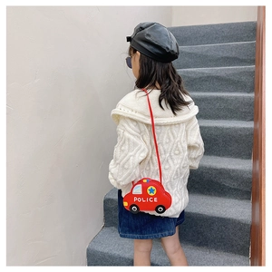 Close-up of a child wearing a red silicone police car crossbody bag with a red strap