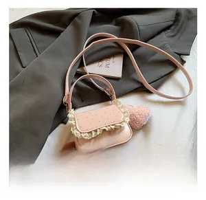 Détail du mini sac rose brillant avec bordure en dentelle blanche et pendentif cœur
