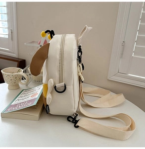 Close-up of white canvas cartoon backpack with animal ears and soft fabric texture