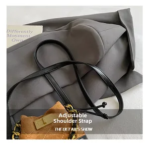 Detail of vintage brown suede mini bag with diamond stitching and adjustable leather strap