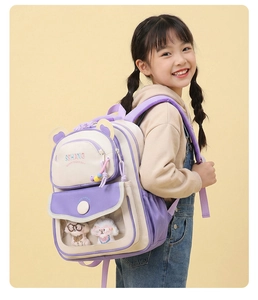 Detail of purple cartoon kids backpack featuring cute bear ears and 3D plush puppy toys