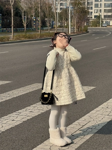 Chic kids quilted bucket bag with chain strap styled in a winter fashion outdoor setting