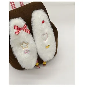 Detail of brown corduroy backpack with plush bunny ears and red checkered strap