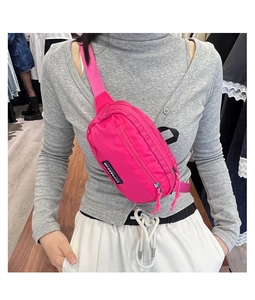 Detail of rose pink nylon chest bag featuring water-resistant fabric and adjustable strap