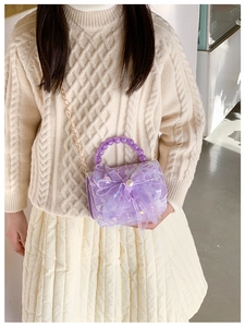 Detail of purple lace crossbody bag with large mesh bow, sequins, and pearl handle