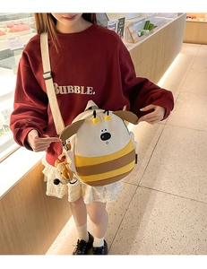 Cute cartoon puppy bee backpack with plush charm worn by a model in casual setting
