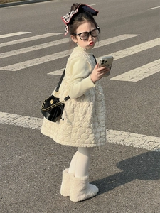 Outdoor shot of child wearing floral quilted vest dress with black quilted chain bag