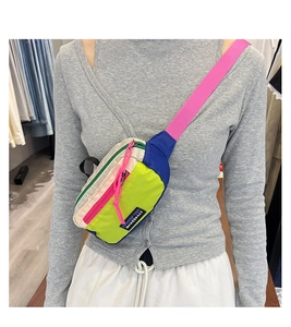 Detail of neon green outdoor crossbody bag with colorful zippers and durable nylon fabric
