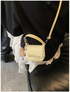 Détail de bordure en dentelle et pois bleus sur sac bandoulière jaune pour enfant