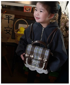 Detail of British style plaid kids backpack with lace trim, bow, and vintage buttons