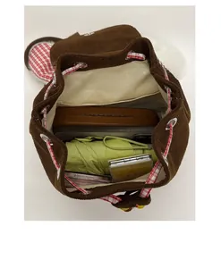Top view of corduroy toddler backpack interior featuring red plaid trim and inner pocket