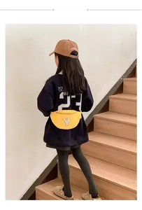 Detail shot of yellow canvas waist bag for kids with white towel-embroidered Y letter