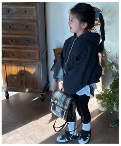 Detailed view of British plaid backpack with lace trim and bow on a child in retro setting