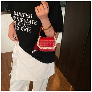 Détail du sac à main rouge à pois pour fille avec dentelle et breloque boule de poil