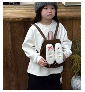 Detailed view of plush white rabbit ears with cute patches on a corduroy kids backpack