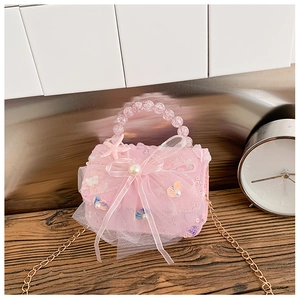 Détail du sac à main rose pour fille avec nœud en résille à paillettes et anse perle
