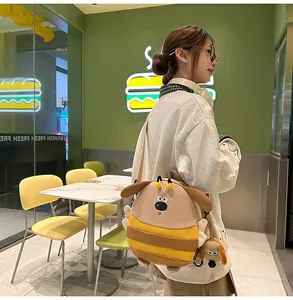 Detail of cute bee-dog plush backpack with furry texture and matching mini charm