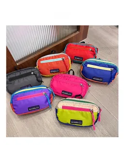 Flat lay detail showing seven colorful waterproof nylon hip packs with zipper pulls