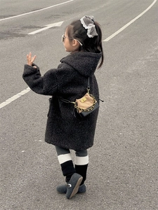 Detail of black faux shearling hooded coat for kids with stylish mini crossbody chain bag