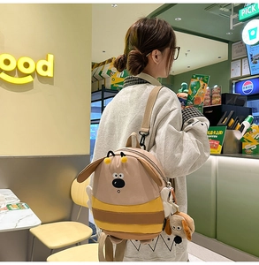 Detail of cute yellow cartoon dog backpack with 3D ears and bee wing accents for women