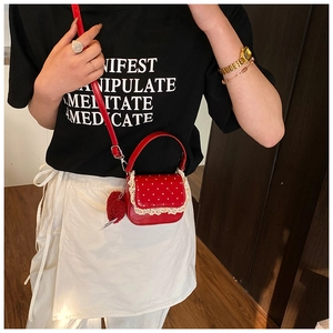 Détail du sac à main rouge à pois pour fille avec dentelle et breloque cœur sur mannequin
