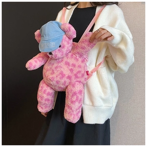 Dettaglio dello zaino a forma di orsetto maculato rosa con cappello di jeans