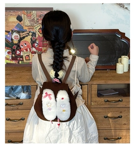 Close-up of kids plush rabbit ear backpack with cute embroidery and red bow details