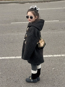 Detail of child wearing a black fleece duffle coat with toggles and a bicolor bucket bag