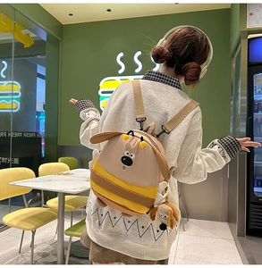 Detail of cute cartoon dog bee backpack with adjustable brown woven shoulder straps