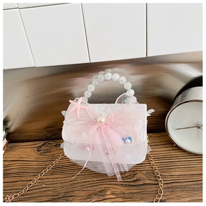 Détail du sac blanc pour fille avec paillettes, poignée en perles et nœud en tulle rose
