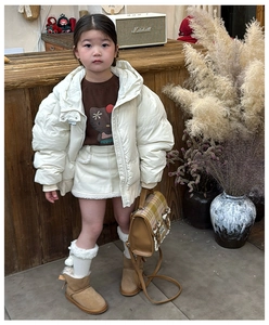Stylish children's plaid backpack paired with a cozy winter outfit and brown snow boots