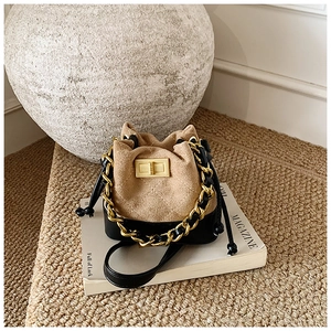 Close-up of contrast stitch bucket bag with gold chain and quilted diamond texture