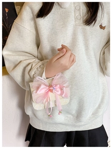 Detail of sweet bow handbag featuring pearl handle and lace fabric on a child model