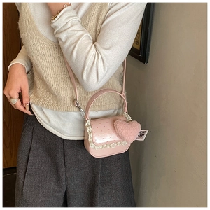 Détail d'un sac rose à pois pour fille avec dentelle blanche et breloque coeur