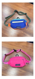Detail of colorful nylon fanny packs with adjustable straps on a wooden surface