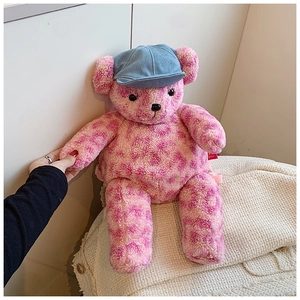 Dettaglio dello zaino orsetto di peluche leopardato rosa con berretto di jeans e etichetta