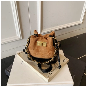 Detail of mini bucket bag with brown suede rhombus stitching and gold twist lock