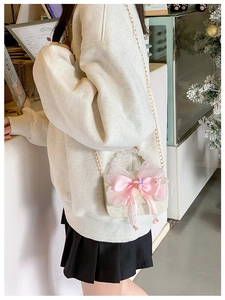 Detail of child princess lace crossbody bag with pink bow, pearl handle and gold chain