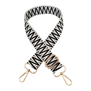Detail of adjustable black and white geometric wide strap with gold hardware hooks