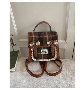 Detailed view of vintage plaid backpack with leather trim, bows and lace edges