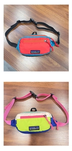 Detail view of two multi-colored nylon waist bags with adjustable straps and front zippers