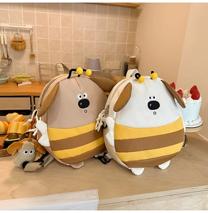 Detail of cute bee-dog cartoon backpack with plush ears and decorative kitchen scene
