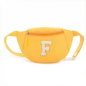 Detail of yellow nylon waist bag for kids with white plush letter F patch and zipper