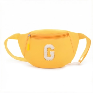Detail of yellow kids fanny pack with chenille letter G patch and gold sequins