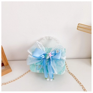Detail of light blue lace kids' purse featuring a satin bow and shell ornaments