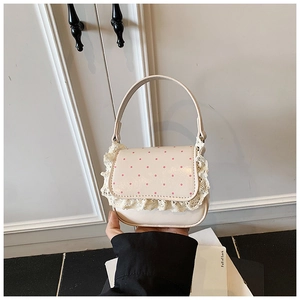 Gros plan du sac crème avec pois roses et bordure en dentelle blanche élégante