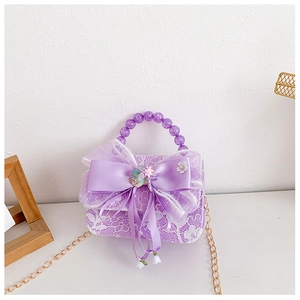 Detailed macro view of purple lace mini bag with large satin bow and pearl handle